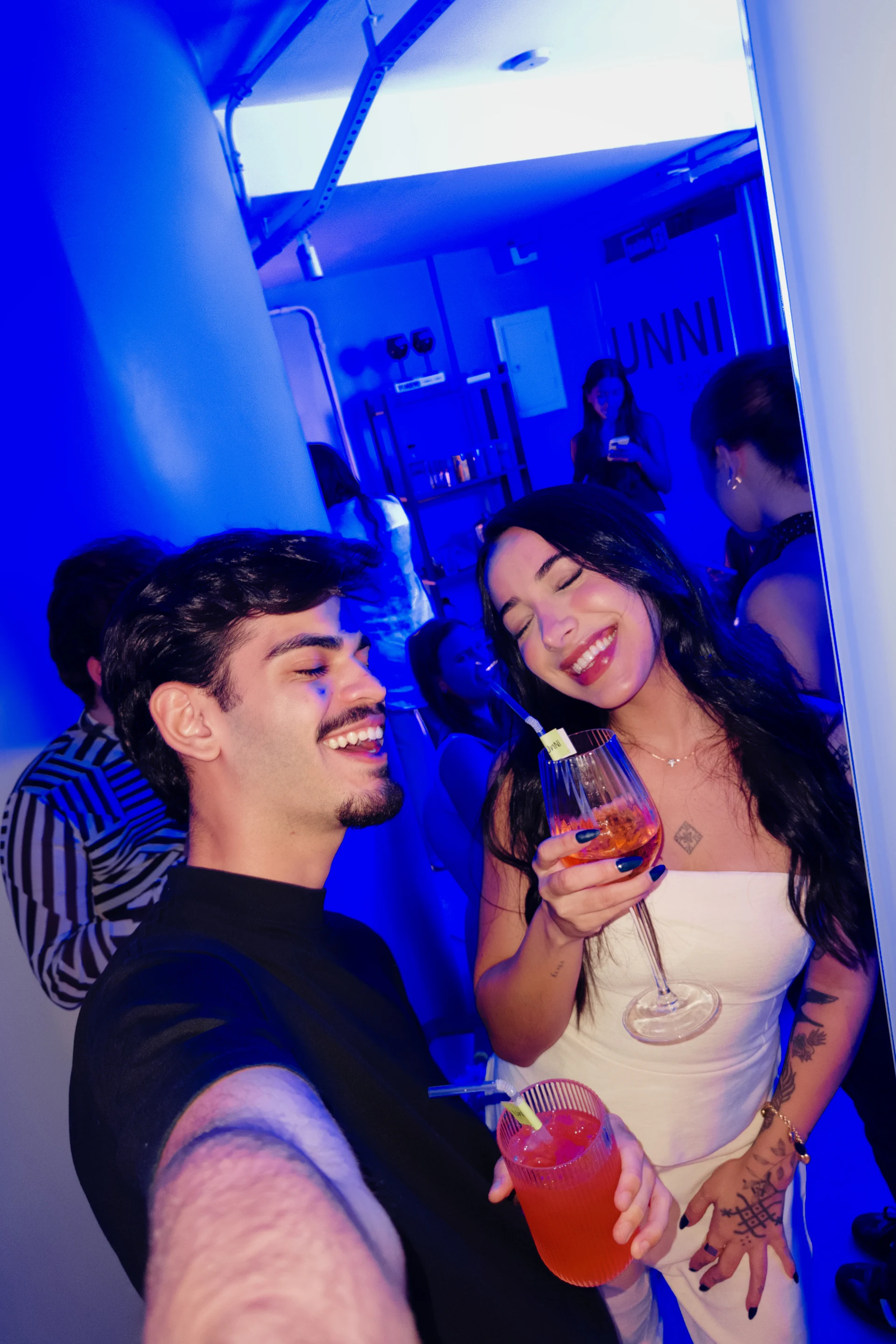 Dois participantes registrando uma selfie no ambiente iluminado em azul